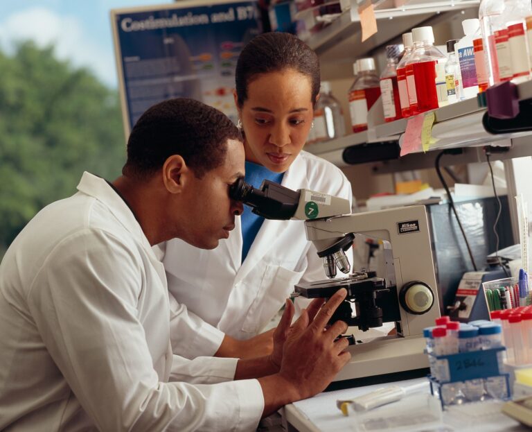 1920px-Researcher_looking_through_microscope