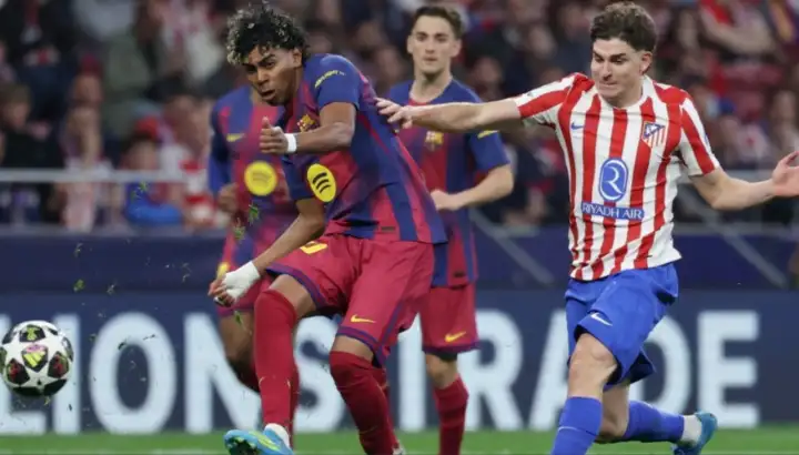 "Fotografía de acción durante el partido de Champions League entre el Atlético de Madrid y el FC Barcelona. En el centro de la imagen, el delantero argentino Julián Álvarez, con la equipación rojiblanca, disputa con intensidad la posesión del balón frente al joven extremo Lamine Yamal, quien viste la camiseta azulgrana". 