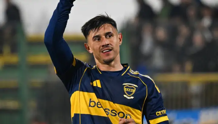 "Adam Bareiro, delantero de Boca Juniors, sonriendo con alegría durante el partido contra Defensa y Justicia. De fondo se observa el campo de juego luego de la victoria por 4 a 0 que selló la goleada de Boca por sobre Defensa y Justicia".